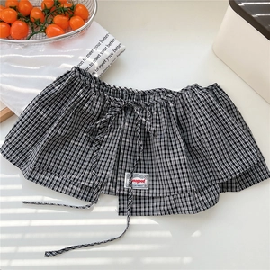 Detail of black and white checkered skirt layer with drawstring and red accent label