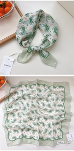 Dettaglio della sciarpa in cotone verde paisley con cuciture a onda e cartellino