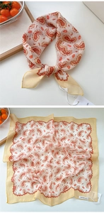 Dettaglio di un foulard quadrato beige con stampa paisley rossa e targhetta prodotto