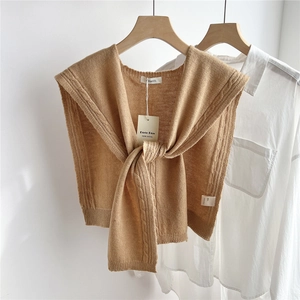 Detail of camel wool cable-knit shawl highlighting premium texture and soft 100% wool material