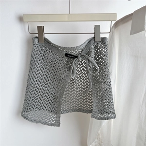 Detail of grey crochet knit mini skirt with hollow out pattern and drawstring waist
