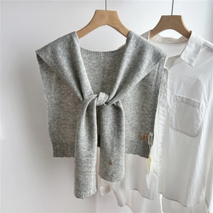 Detailed knit texture of light grey 100% wool shawl draped over a white shirt