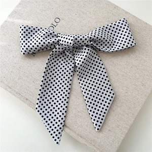 Nœud à cheveux blanc chic à pois noirs avec longs rubans sur fond de lin naturel