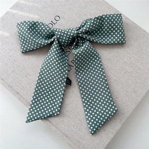 Détail du nœud en soie à pois vert foncé rétro montrant la texture du tissu fin