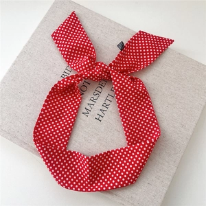 Gros plan d'un foulard rouge à pois en 100% polyester avec détail de nœud