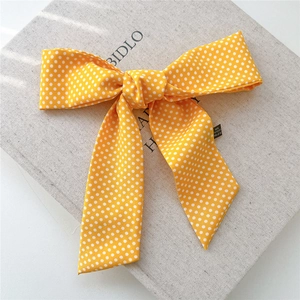 Détail d'un nœud papillon jaune à pois en tissu 100% polyester de haute qualité