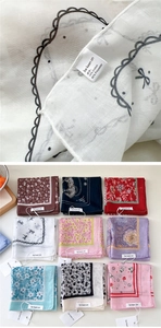 Detailed close-up of printed cotton-linen blend square scarves with reinforced stitching