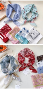 Detail showing various cotton linen square scarves with paisley and cherry prints