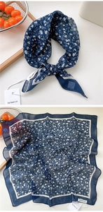 Detail of navy blue floral square scarf showing fabric texture and printed pattern