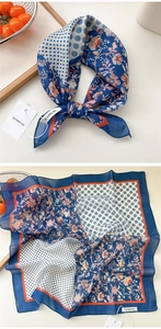 Detail of vintage blue silk scarf with floral and polka dot patterns on wooden tray