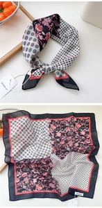 Detailed flat lay of a square silk scarf with red floral and black polka dot prints