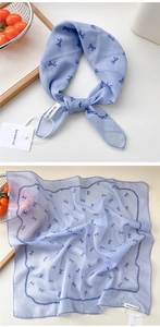 Macro detail of a light blue cotton linen scarf with blue bow and white polka dot prints