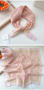 Detail of floral silk scarf in pink with yellow flowers and elegant brand tag