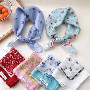 Various floral cotton linen scarves arranged with a rustic tray and red berries
