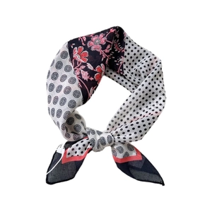 Floral and polka dot cotton-linen neck scarf tied in a stylish knot on white background