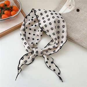 Close-up of polka dot linen-cotton scarf showing knot detail and textured fabric