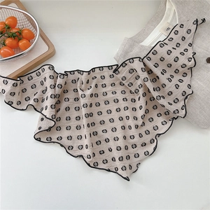 Close-up of beige polka dot cotton linen neckerchief with black hem and pleated texture
