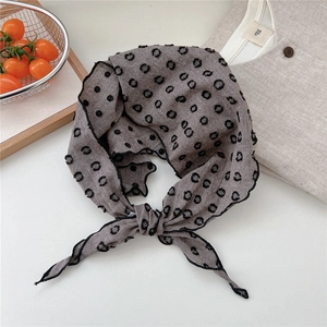 Detailed view of gray linen neckerchief with black 3D polka dots and fine edge stitching