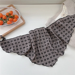 Detail of dark grey polka dot scarf with delicate ruffled edges and sheer texture