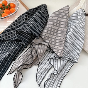 Close-up of striped cotton linen neck scarves with fine rolled edges and polka dot patterns