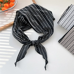 Detail view of black and white striped cotton linen neck scarf with polka dot pattern