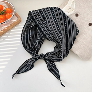 Detail of black and white striped linen scarf with polka dots in a bright lifestyle setting