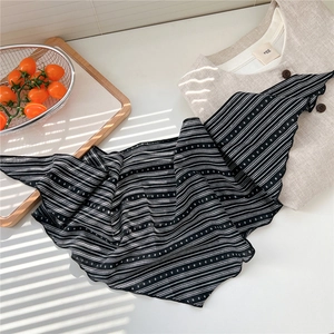 Detail of striped and polka dot cotton-linen scarf with natural sunlight shadow effect