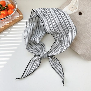 Detailed view of striped cotton linen triangle scarf with dots on a neutral background