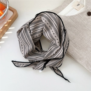 Detailed view of striped linen scarf with polka dots and black stitched edges