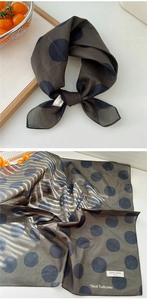 Detailed macro view of retro dark brown polka dot cotton scarf with brand wash label