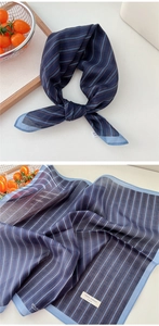 Detail of navy blue striped cotton scarf showing fabric texture and styled knot look