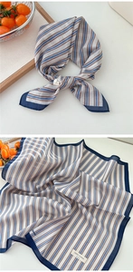 Detail of striped cotton square scarf showing fine texture and blue-brown diagonal patterns