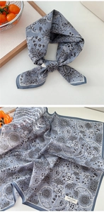Detail of blue cotton bandana showing paisley pattern and 100% cotton fabric label