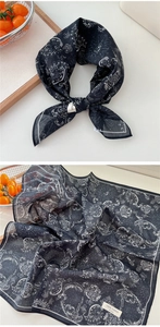 Detail of 100% cotton square scarf featuring black and white paisley floral patterns