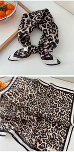 Detail of soft leopard print cotton neckerchief featuring classic brown tones and striped edges