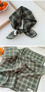 Detail view of dark green plaid cotton square scarf with white stitched edges
