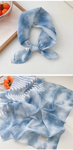 Detail of blue and white tie-dye cotton scarf with soft texture and 100% cotton label