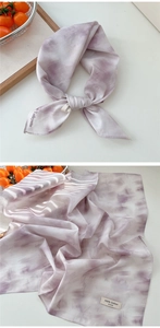 Detail of light purple tie-dye cotton scarf showing fabric texture and 100% cotton label