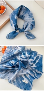 Macro detail of blue and white tie-dye cotton scarf with soft watercolor texture