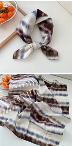Detailed macro view of 100% cotton scarf texture with blue tie-dye stripes