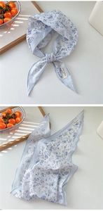 Detail eines hellblauen Baumwoll-Bandanas mit Blumenmuster und 100% Baumwolle-Etikett
