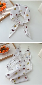 Detail eines schmalen Baumwollschals mit Vintage-Blumenmuster und grau gestreifter Kante