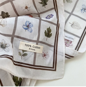 Gros plan d'un foulard en coton léger avec motifs floraux vintage et carreaux