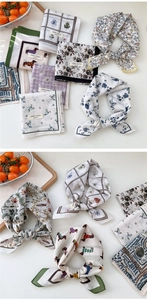 Détail d'un petit foulard carré en coton doux avec motifs floraux et coutures soignées