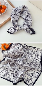Gros plan d'un foulard en coton à imprimé floral avec bordure noire roulée