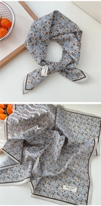 Détail d'un petit foulard carré en coton à imprimé floral bleu clair et texture douce