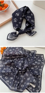 Détail d'un foulard en coton bleu marine à motif floral blanc et étiquette coton