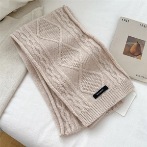 Close-up of 100% wool knit scarf featuring premium diamond and cable patterns