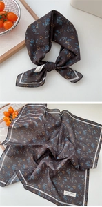 Détail du foulard en coton à motifs floraux bleus et jaunes avec bordure contrastée