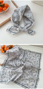 Détail d'un foulard en coton à motifs floraux bleus avec bordure bleu marine